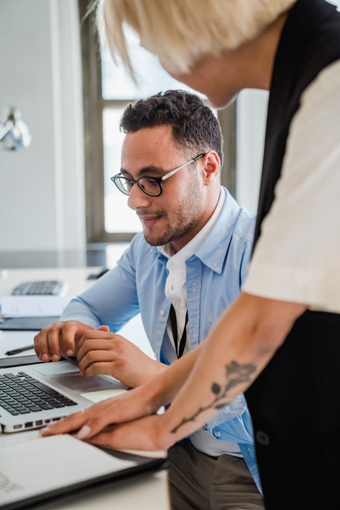 Mastering the First Impression: Your intriguing post title goes here Two professionals collaborating in a modern office setting, engaged in project discussion.