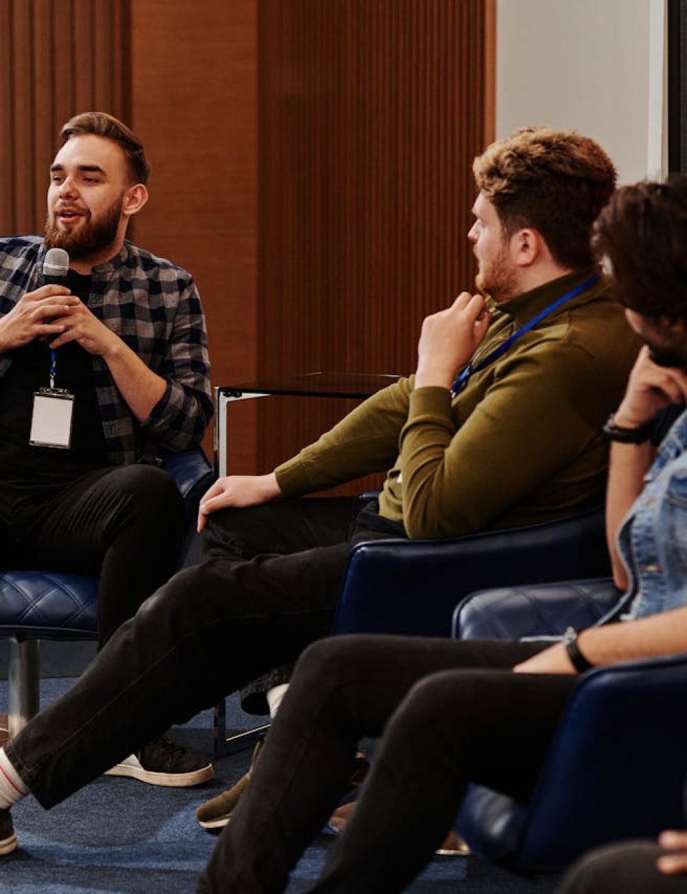Inicio Group of young adults engaging in a lively panel discussion, fostering collaboration.